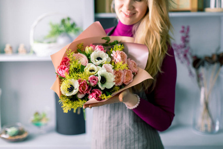 一大束漂亮的混合花在女人手里。花店概念。漂亮的新鲜花束。送花。