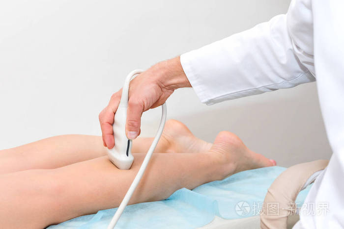 女性病人的腿上用一个装置进行超声波检查在现代诊所工作的外科医生痰
