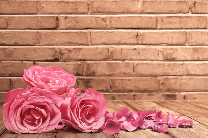 pink roses and rose petals on a wooden table