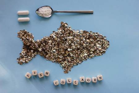 Fish collagen capsules and powder on trendy blue background. 