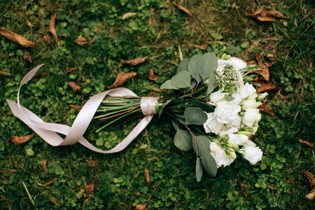wedding bouquet with white roses on green grass background 