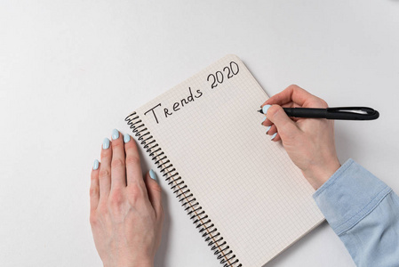 2020年趋势。预测和规划。白笔和女性背景的笔记本。