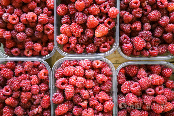 农贸市场出售的一盘盘新鲜多汁的覆盆子从上面看树莓托盘