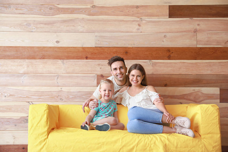 木墙旁有沙发的快乐小家庭