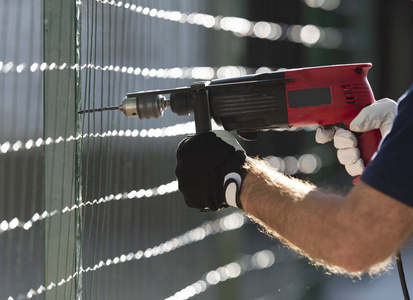 Male hand holding drilldrive while screwing screw 