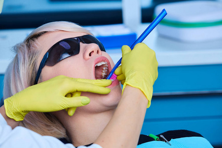 在牙医诊所接受牙科治疗的美女病人。看牙医的女人