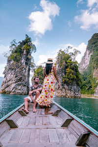 这对夫妇乘船在泰国小榄湖Chiew lan lake的浩索国家公园Khao Sok National Park的巨型湖泊