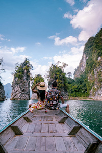 这对夫妇乘船在泰国小榄湖Chiew lan lake的浩索国家公园Khao Sok National Park的巨型湖泊