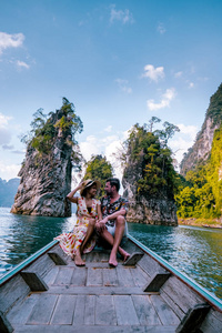 这对夫妇乘船在泰国小榄湖Chiew lan lake的浩索国家公园Khao Sok National Park的巨型湖泊