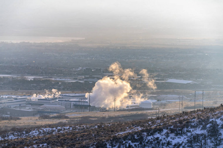 冬天在雪地上散发蒸汽的工厂图片