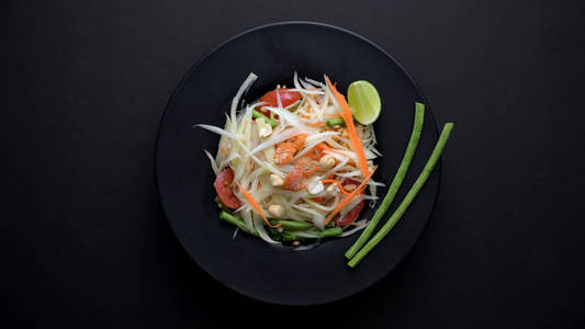 Top view of papaya salad or Somtum on black plate 