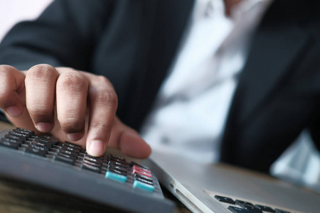 Close up of businessman use calculator on table 