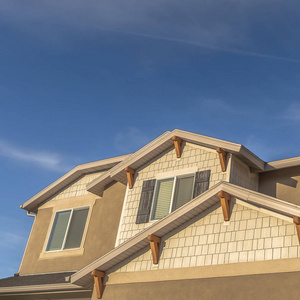 方形的房子,前面有山墙屋顶和老虎窗,映衬着蓝天白云照片