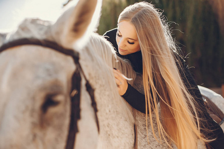 Elegants girl with a horse in a ranch