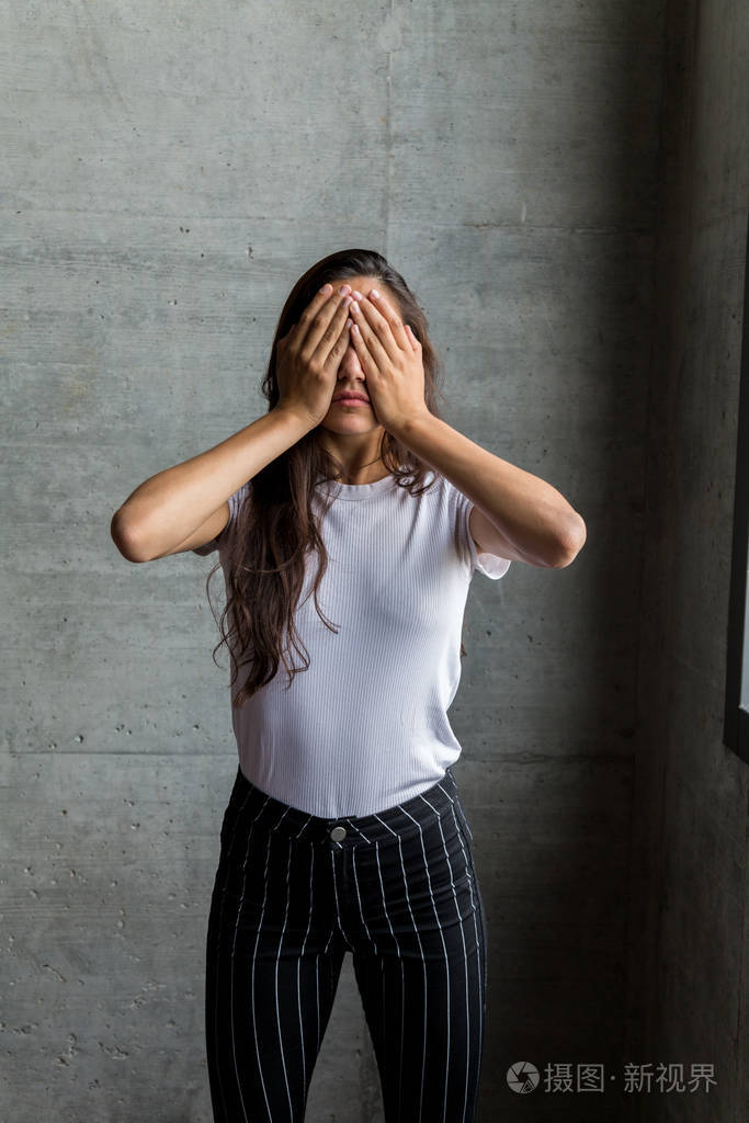室内双手捂眼女子
