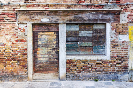 旧砖墙外墙，窗户用木板封住。