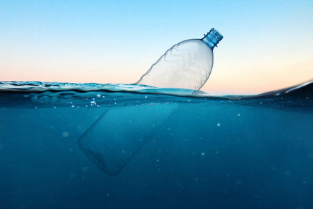 Empty plastic bottle floats in water. Ocean pollution concept. G