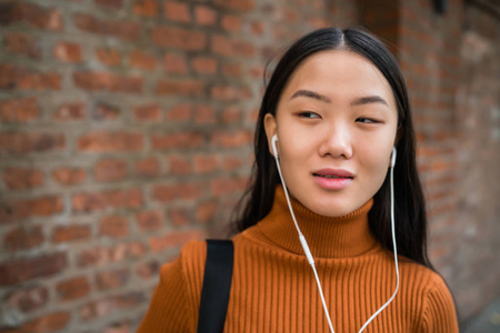 听音乐的亚洲女人。