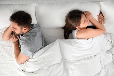 Unhappy couple with relationship problems after quarrel in bed, 