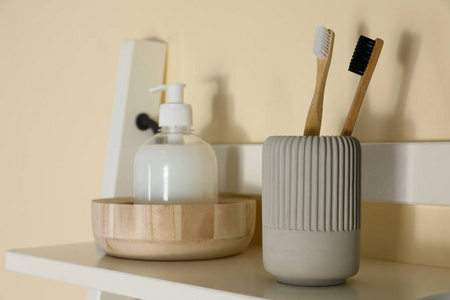 Shelving unit with toiletries near light wall indoors. Bathroom 