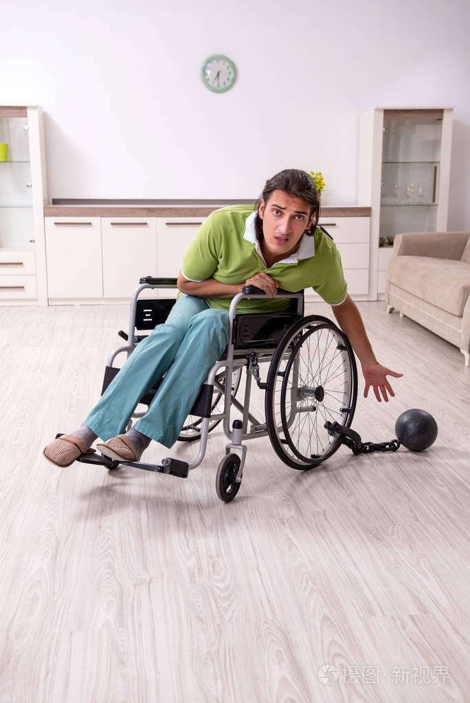 年轻男性残疾人在轮椅上受苦在家