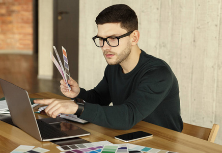 设计自由职业者在办公室选择颜色样本笔记本电脑