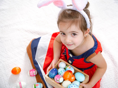 带着复活节彩蛋和兔子耳朵的可爱小女孩。