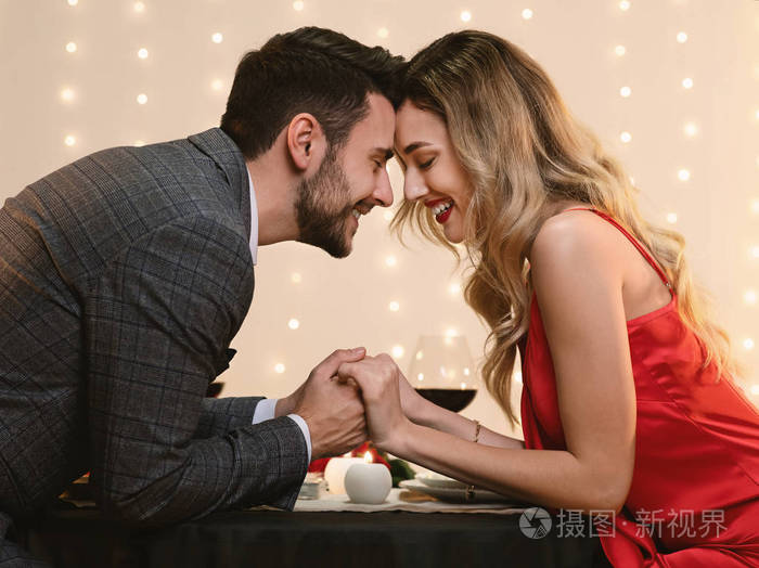 甜蜜的情侣在餐厅浪漫晚餐中牵手照片-正版商用图片28scpm-摄图新视界