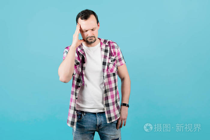 一个留着胡茬的男人用手捂着头描绘着痛苦