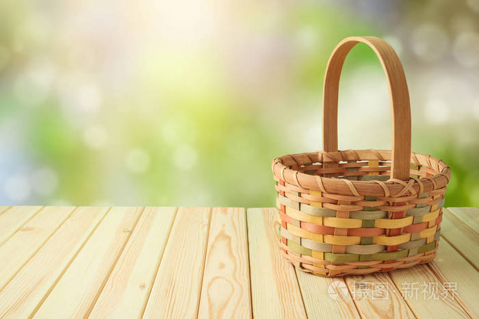 emptybasketonwoodentableovergreenbokehbackgroundspring