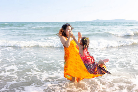 快乐的亚洲人家庭和孩子们玩耍的海滩