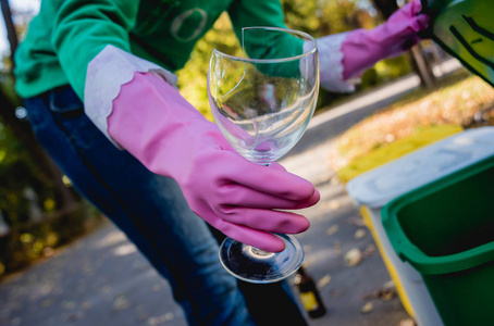 Volunteer girl sorts garbage in the street of the park. Concept 