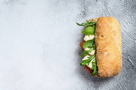西巴塔三明治配新鲜山羊奶酪梨果酱和芝麻菜。灰色背景。俯视图。文本空间