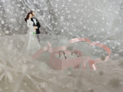 婚礼概念。新婚小雕像，背上有结婚戒指