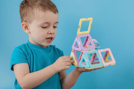男孩透过颜色构造器中的形状与磁铁的连接
