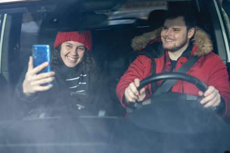 一对情侣在车里穿着冬装开车聊天照片