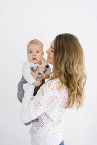 young mother holds her fivemonthold son in her arms against a 