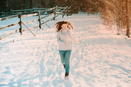 多好的冬天啊。兴高采烈的年轻女子在森林附近的雪地里奔跑。