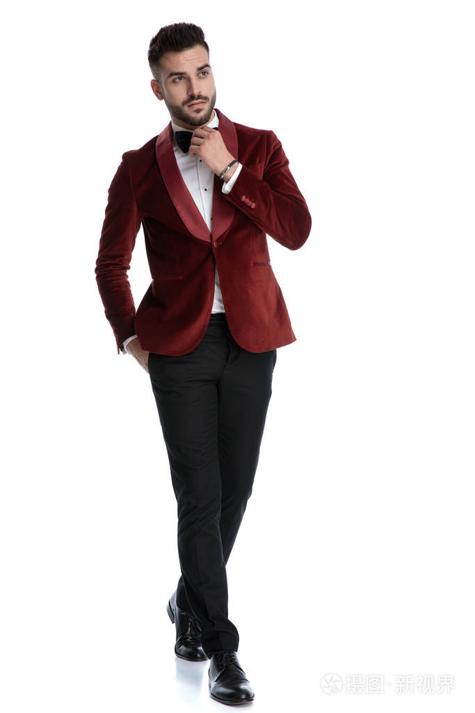 穿着燕尾服的性感年轻模特走路系着蝴蝶结