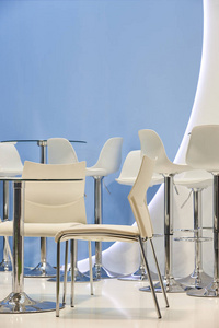White chairs and tables in a blue room. Decoration 