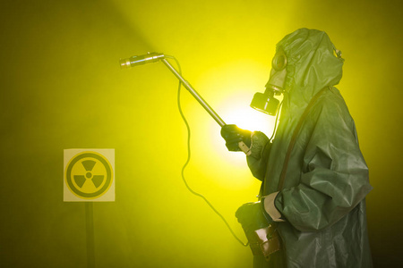 辐射污染和危险概念深色背景下穿着防护服和防毒面具的人