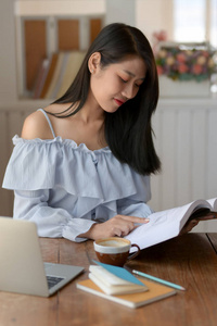 Close up view of a girl reading book while siting in comfortable