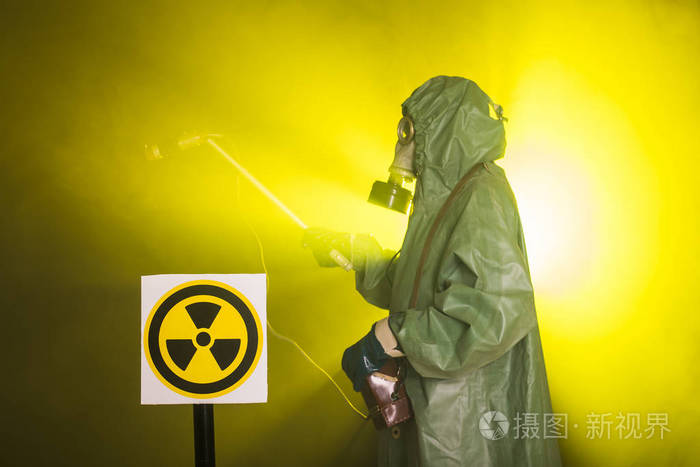辐射和危险概念戴防毒面具和化学防护服的人测量放射性的工人