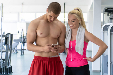年轻夫妇在健身房用手机