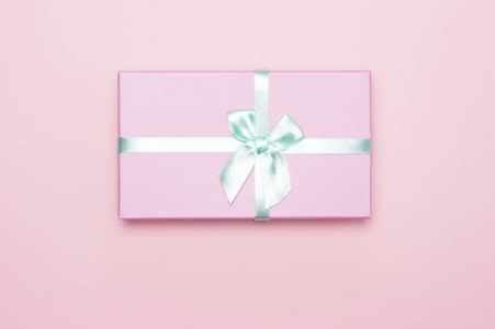 平铺，粉红色礼品盒，粉红色背景上有薄荷色atlas丝带