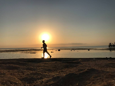 一个人在岸边迎接黎明.一个人注视着海上的朝阳.照片