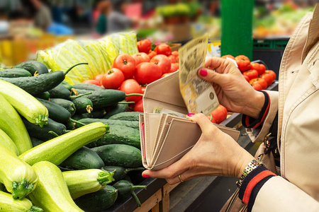 在绿色市场买新鲜有机水果和蔬菜的妇女。