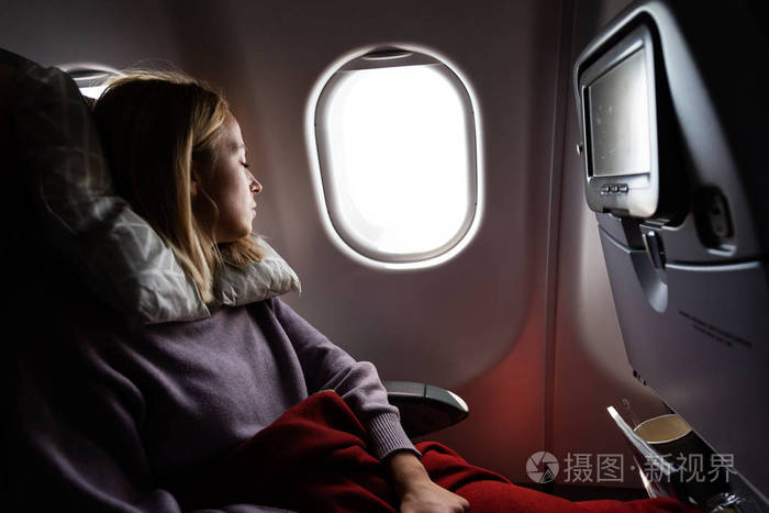 坐飞机旅行时疲惫的金发随意的白人女士睡在座位上飞机商业运输