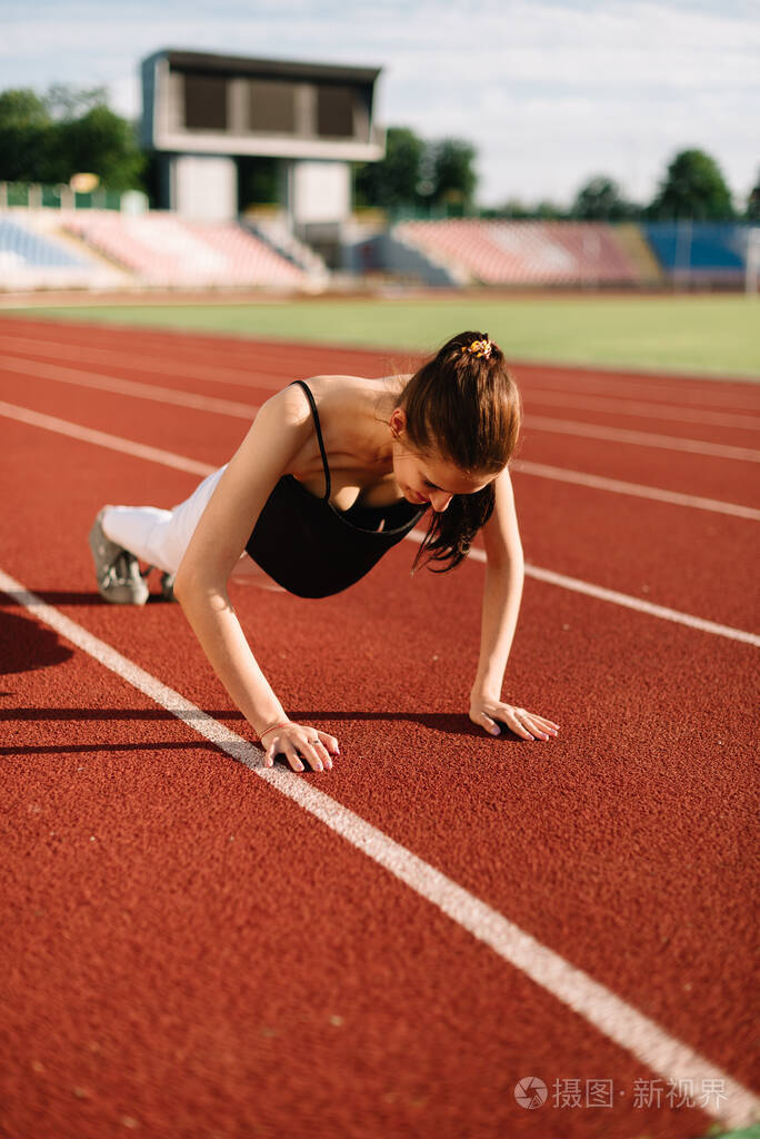 一个阳光明媚的日子女运动员在赛场上拼命地跑