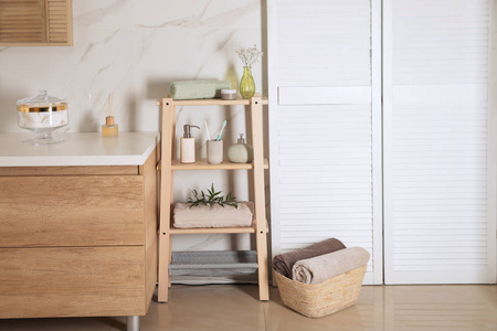 Shelving unit with toiletries in stylish bathroom interior 